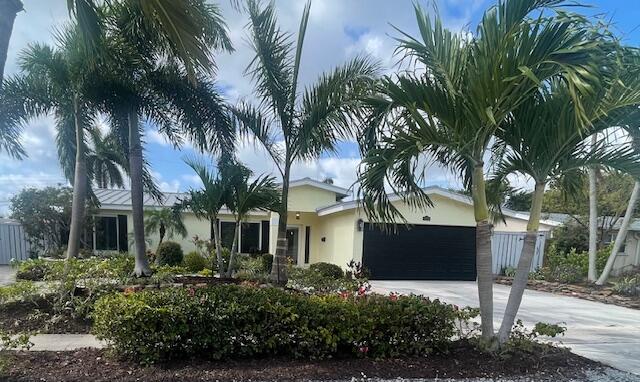 1028 SE 13th Ct, Deerfield Beach, FL 33441 - ranch-style house with fence, an attached garage, driveway, and stucco siding