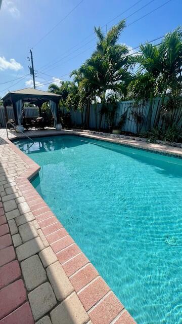 1028 SE 13th Ct, Deerfield Beach, FL 33441 - view of swimming pool featuring a gazebo, a fenced backyard, and a fenced in pool