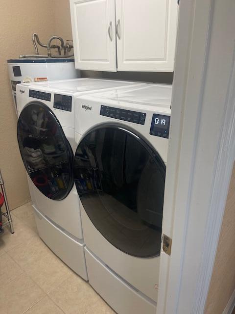 1028 SE 13th Ct, Deerfield Beach, FL 33441 - clothes washing area with cabinet space, independent washer and dryer, light tile patterned floors, and water heater