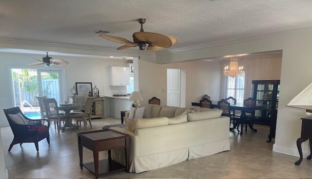 1028 SE 13th Ct, Deerfield Beach, FL 33441 - living room with crown molding, ceiling fan with notable chandelier, and visible vents