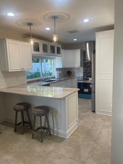 1028 SE 13th Ct, Deerfield Beach, FL 33441 - kitchen featuring visible vents, a peninsula, tasteful backsplash, a sink, and appliances with stainless steel finishes