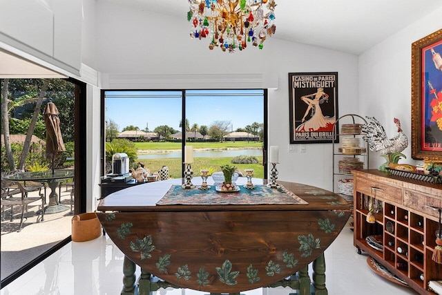 dining space with lofted ceiling and a water view