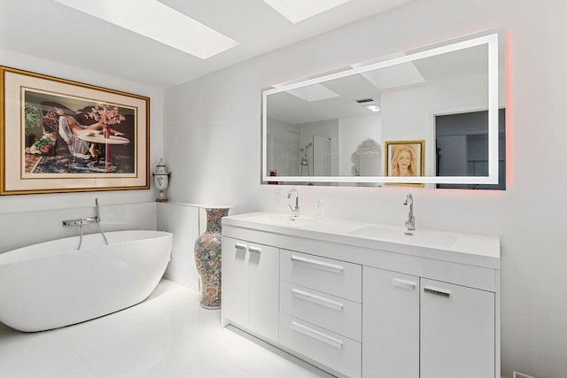 bathroom with a skylight, a sink, a shower stall, and double vanity