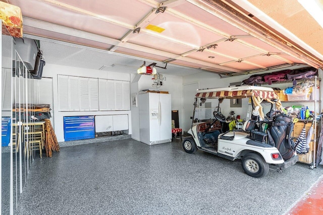 garage featuring a garage door opener and white refrigerator with ice dispenser