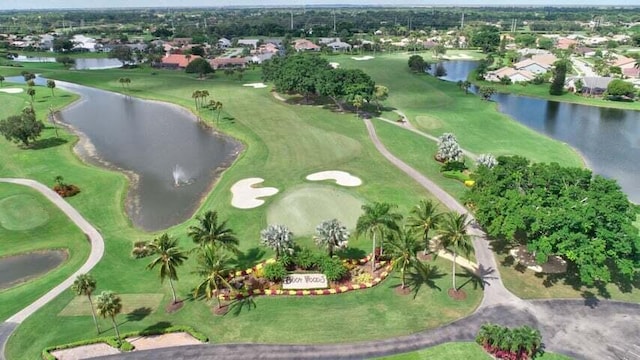 drone / aerial view featuring golf course view, a residential view, and a water view