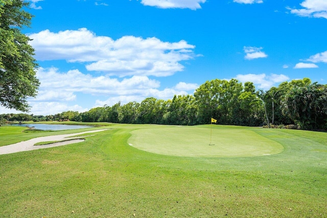 view of community featuring a yard, view of golf course, and a water view