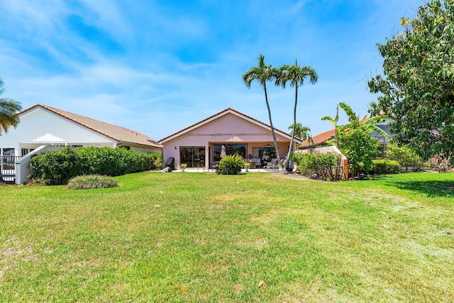 back of property featuring a yard, a ceiling fan, a patio area, and stucco siding