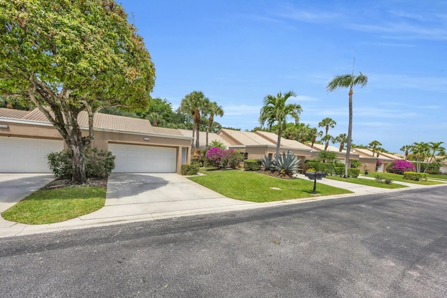 11206 Applegate Cir, Boynton Beach, FL 33437 - view of front facade with concrete driveway, a front yard, stucco siding, and a garage