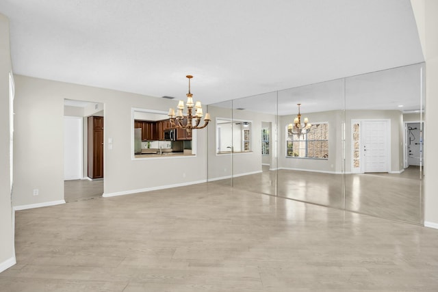 11206 Applegate Cir, Boynton Beach, FL 33437 - unfurnished dining area with baseboards, light wood-type flooring, and an inviting chandelier