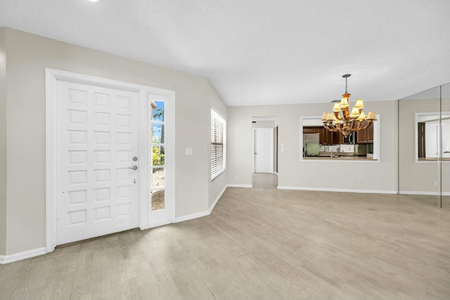 11206 Applegate Cir, Boynton Beach, FL 33437 - foyer entrance with a chandelier, baseboards, and light wood-style flooring