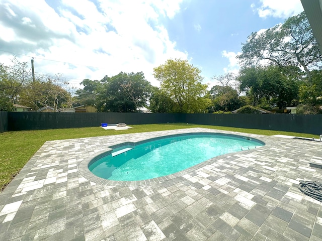 view of swimming pool with a yard, a patio area, a fenced in pool, and a fenced backyard