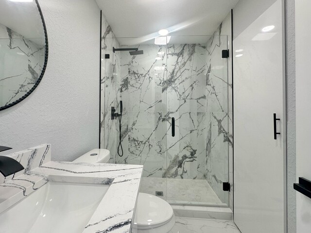 bathroom featuring a textured wall, marble finish floor, a marble finish shower, and toilet