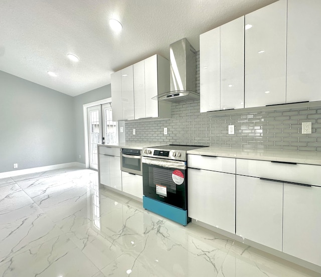 kitchen featuring marble finish floor, stainless steel appliances, wall chimney exhaust hood, baseboards, and decorative backsplash
