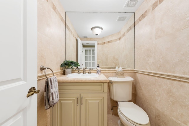2917 S Ocean Blvd Unit 103, Highland Beach, FL 33487 - half bathroom with toilet, vanity, visible vents, and tile walls