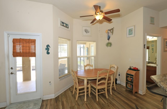 dining area with baseboards, a ceiling fan, dark wood-style flooring, and a healthy amount of sunlight