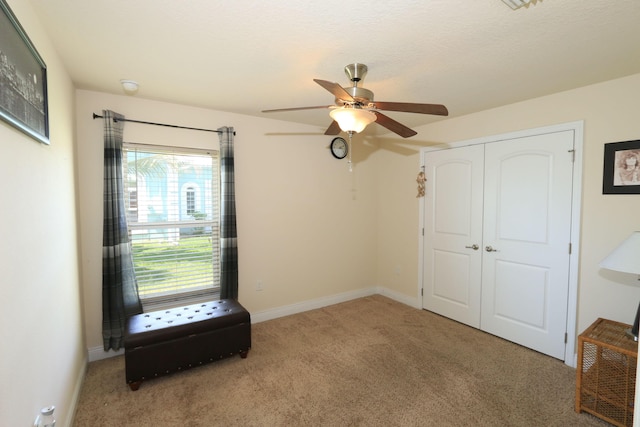 unfurnished bedroom with carpet flooring, ceiling fan, baseboards, and a closet