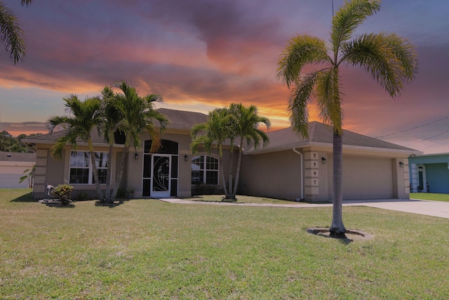 view of front of property with concrete driveway, an attached garage, a yard, and stucco siding