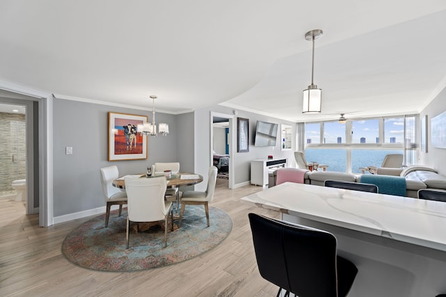 dining space featuring light wood-type flooring, baseboards, ornamental molding, and ceiling fan with notable chandelier