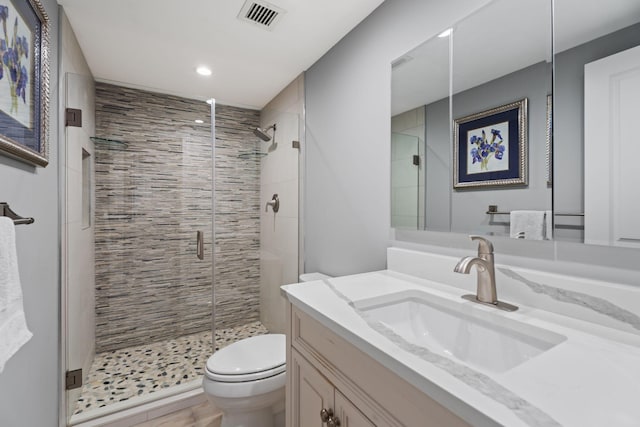 bathroom featuring a stall shower, vanity, toilet, visible vents, and recessed lighting