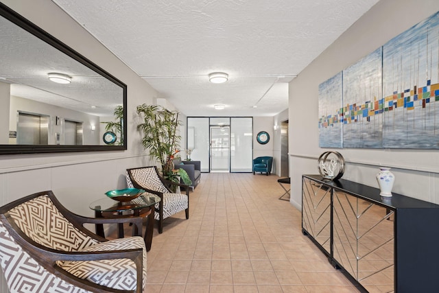 corridor with a textured ceiling and light tile patterned floors