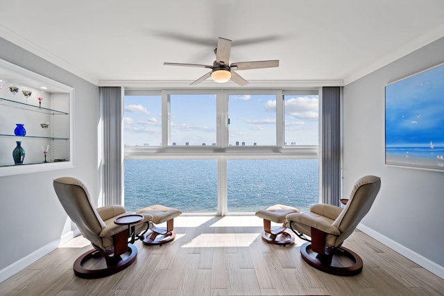 sitting room featuring baseboards, a ceiling fan, wood finished floors, and crown molding