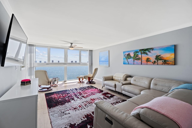 living area featuring wood finished floors, crown molding, baseboards, expansive windows, and ceiling fan
