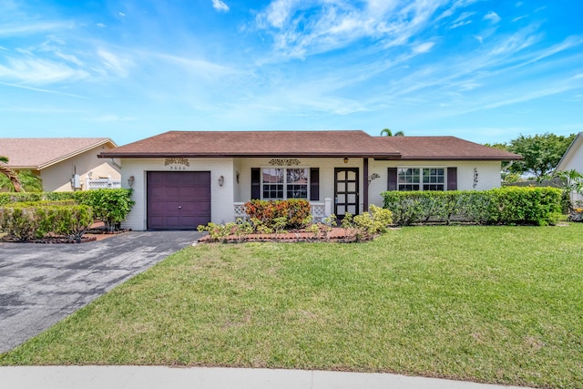 single story home featuring brick siding, an attached garage, a front lawn, and aphalt driveway