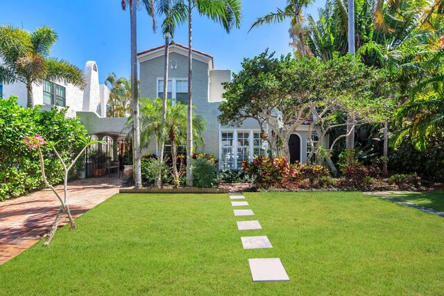 138 Greymon Dr, West Palm Beach, FL 33405 - rear view of property with a lawn and stucco siding
