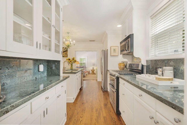 138 Greymon Dr, West Palm Beach, FL 33405 - kitchen featuring backsplash, a sink, white cabinets, a notable chandelier, and stainless steel appliances