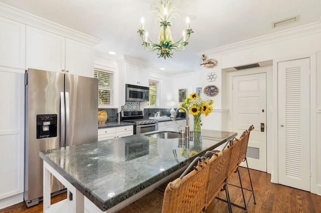 138 Greymon Dr, West Palm Beach, FL 33405 - kitchen with appliances with stainless steel finishes, ornamental molding, white cabinetry, and a notable chandelier