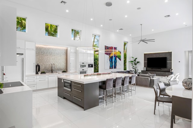5784 Vintage Oaks Cir, Delray Beach, FL 33484 - kitchen with stainless steel microwave, a sink, modern cabinets, oven, and white cabinetry