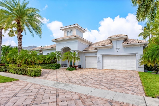 5784 Vintage Oaks Cir, Delray Beach, FL 33484 - mediterranean / spanish-style home featuring stucco siding, decorative driveway, a tile roof, and a garage