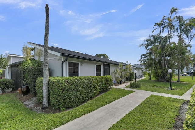 exterior space with stucco siding and a yard