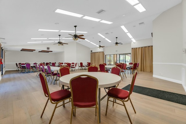 dining room with a skylight, ceiling fan, light wood-type flooring, and visible vents