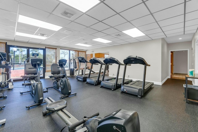gym featuring baseboards, visible vents, and a drop ceiling