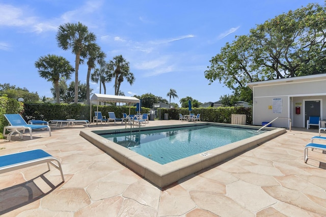 community pool featuring fence and a patio area