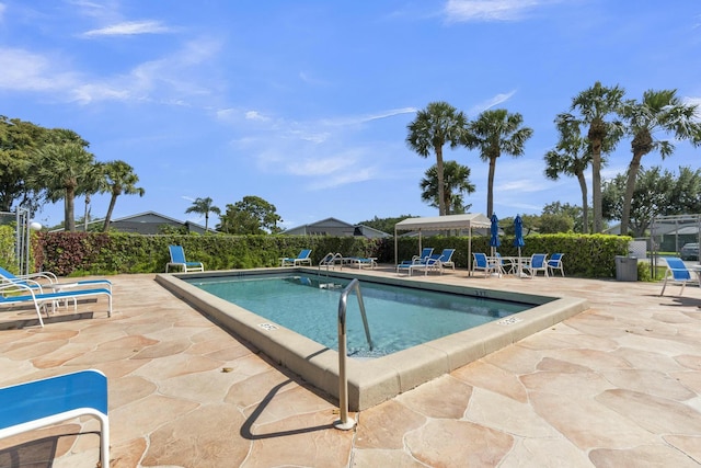 pool with a patio area and fence