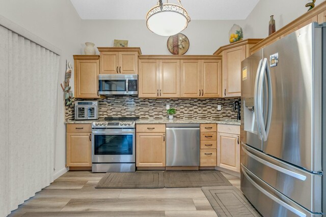 kitchen featuring stacked washer and clothes dryer, light brown cabinetry, light wood-style flooring, appliances with stainless steel finishes, and backsplash