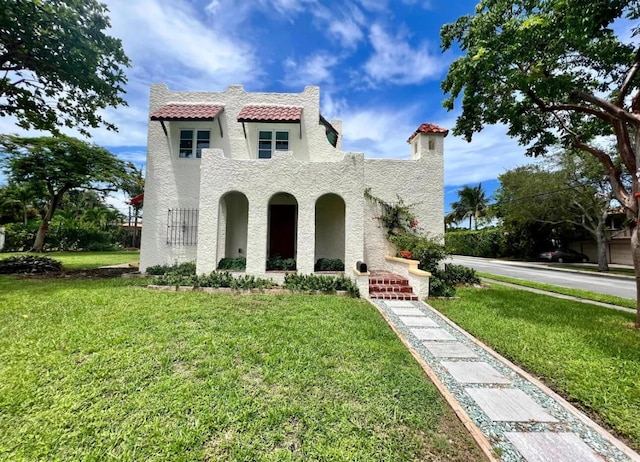 mediterranean / spanish-style house with a front yard and stucco siding