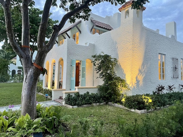 view of property exterior featuring stucco siding and a yard