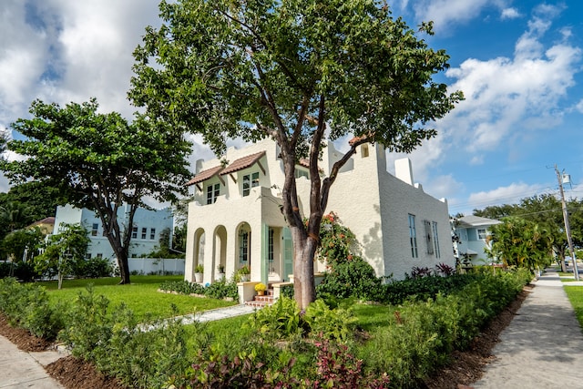 view of property exterior with a yard, fence, and stucco siding