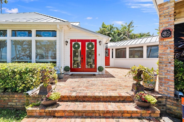 property entrance featuring a standing seam roof, french doors, and metal roof