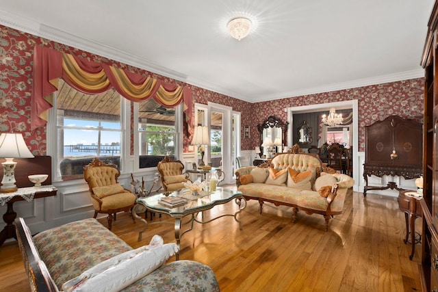 living room featuring wallpapered walls, a wainscoted wall, hardwood / wood-style flooring, and an inviting chandelier