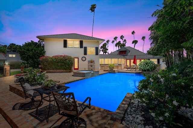 view of swimming pool with a pool with connected hot tub, a patio, and fence