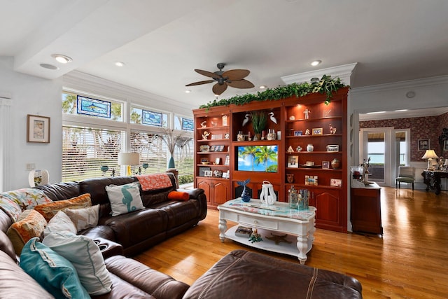 living area featuring ceiling fan, a wealth of natural light, and ornamental molding
