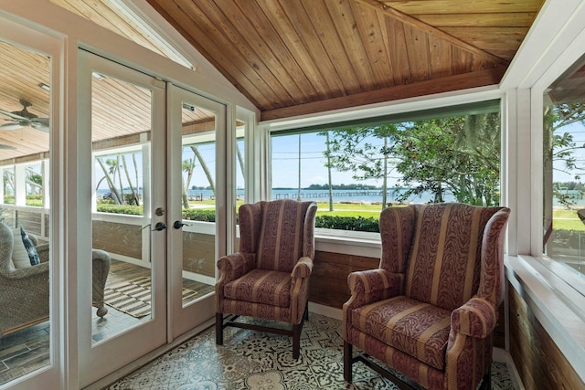 sunroom featuring plenty of natural light, french doors, and a water view