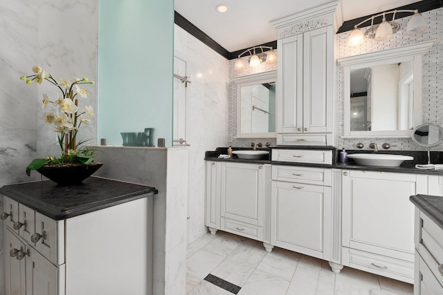 full bathroom featuring marble finish floor, ornamental molding, a sink, and double vanity