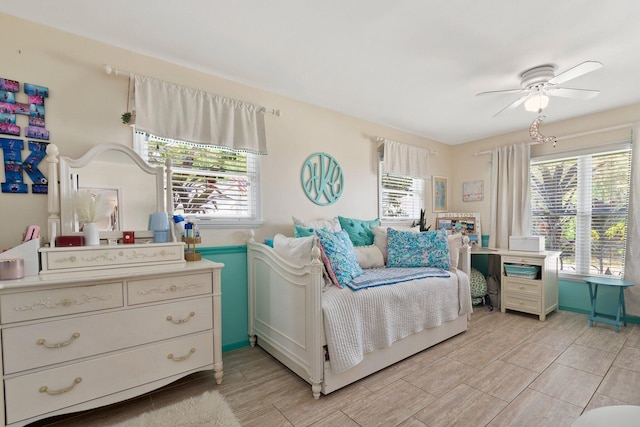 bedroom with wood finish floors, a ceiling fan, and multiple windows