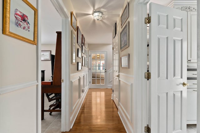 hallway with light wood-style flooring and a decorative wall