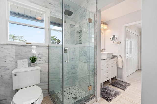 full bathroom featuring toilet, vanity, and a marble finish shower